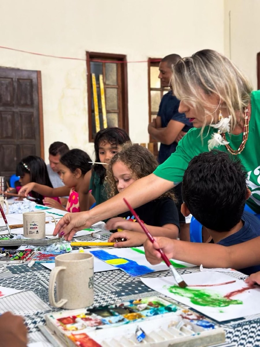 Cristine Aoni orientando crianças em uma oficina de aquarela