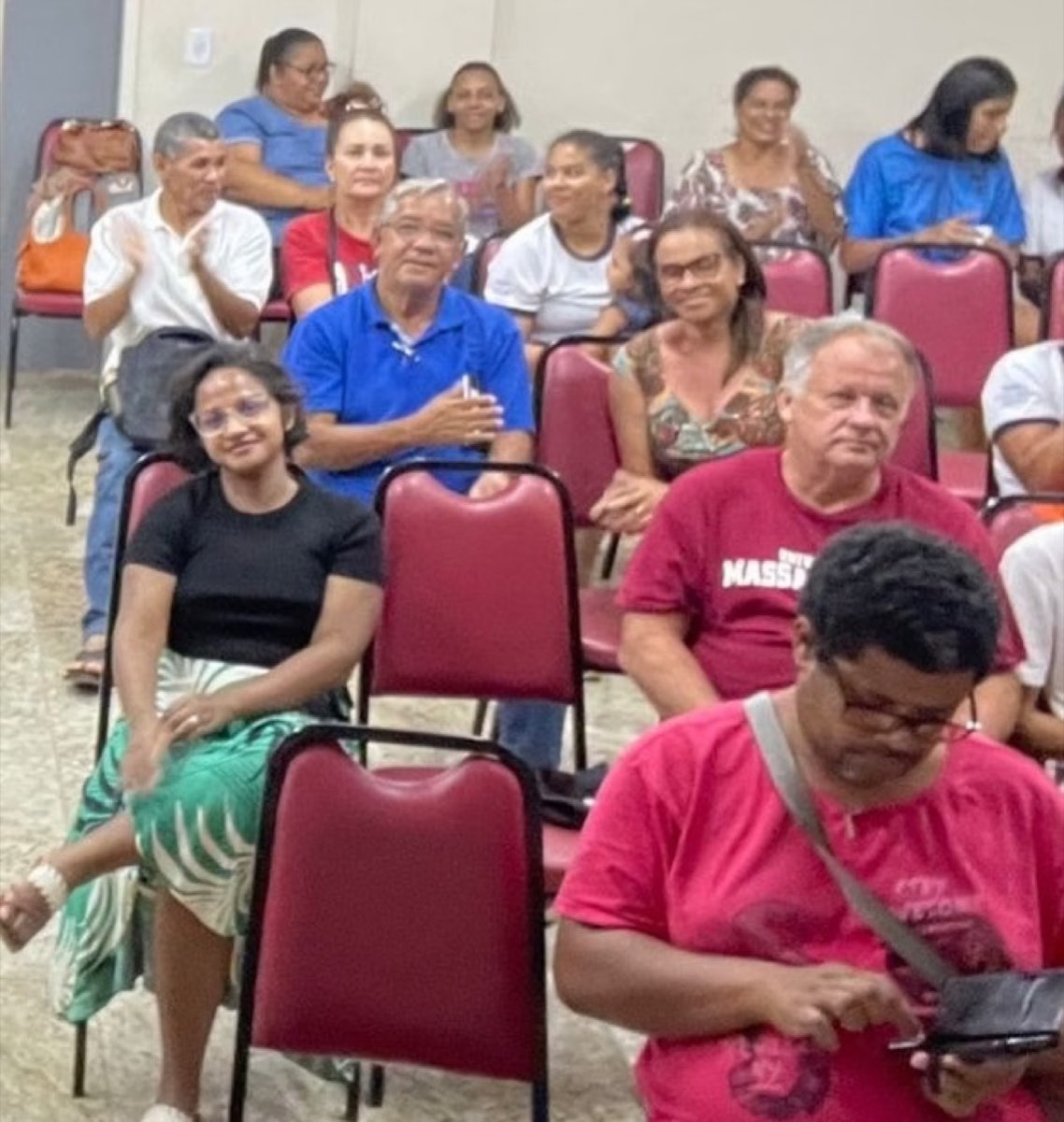 Grupo de participantes sentados, sorrindo e aplaudindo em uma capacitação